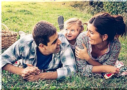 Family lying on the grass and laughing together