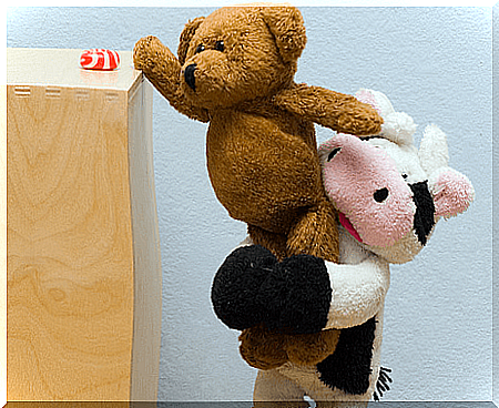 Teddy bear helps other teddy bear reach for candy as it is a good person