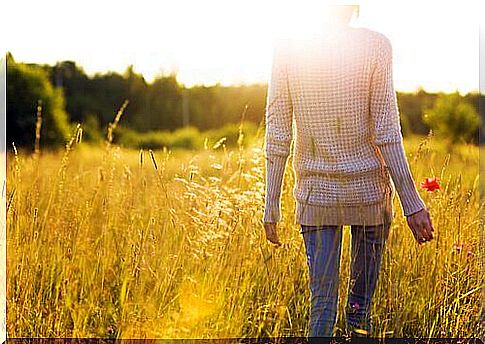 Woman walking on field in sunlight