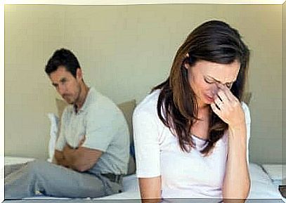 Woman crying in front of man in bed