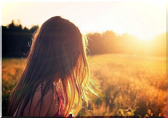 Woman in field in sunlight enjoying happiness