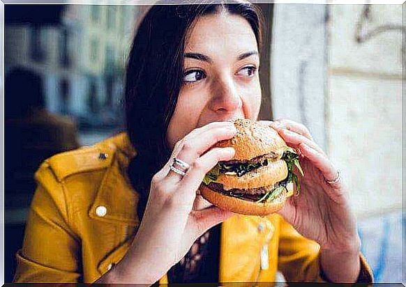 Woman eating big burger