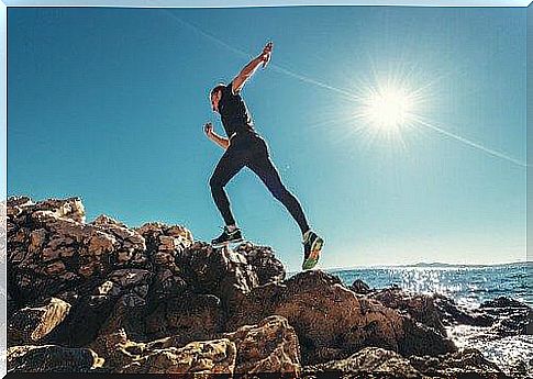 Man running on rocks by sea