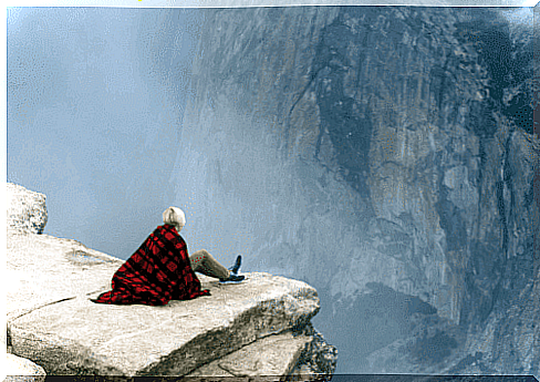 Woman sitting on a rock high up to overcome a phobia of heights