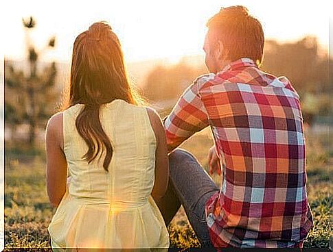 Two people are sitting and talking on the lawn