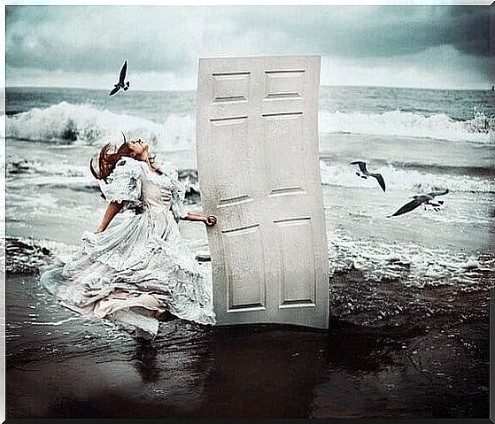 Woman at sea edge with white door