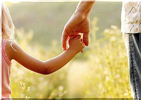 Girl holds in father's hand