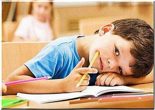 Boy rests head on table at school