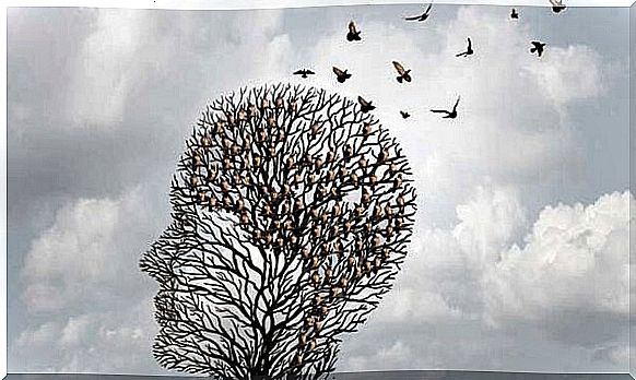 Birds fly away from the tree shaped like a head as a symbol of Alzheimer's