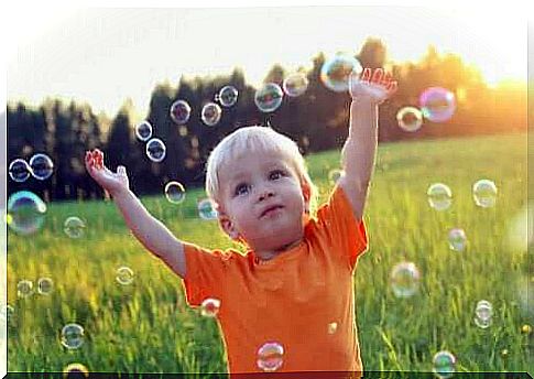 A boy is playing with soap bubbles