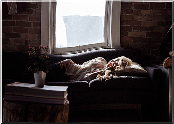 Woman sleeping on sofa and showing how emotions affect our body through psychosomatic disorders