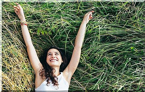 Woman on grass is happy because of psychological well-being