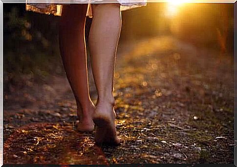 Woman walking barefoot in a forest