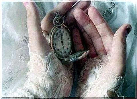 Person holding clock in his hands and thinking of old memories