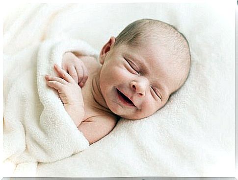 little baby lying in bed and smiling