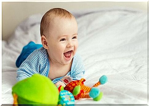 baby playing and smiling in bed