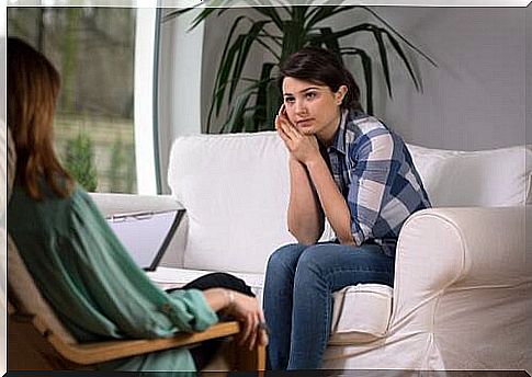 Woman on sofa talking to another woman