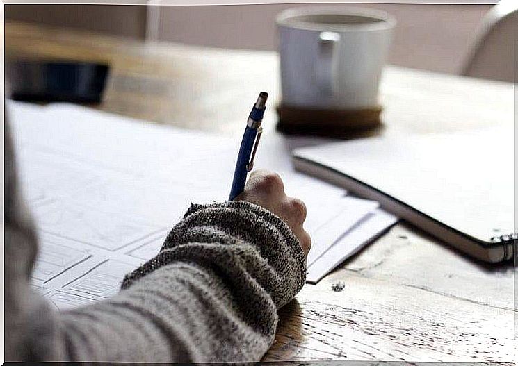 Person with pencil and paper on desk