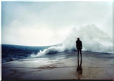 Person standing in front of huge wave at port