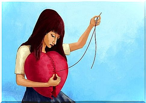 woman sews a broken heart